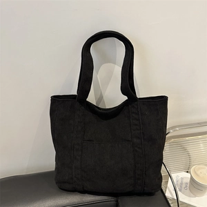 Minimalist black corduroy tote bag with front pocket and shoulder straps for women