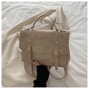Dettaglio borsa beige vintage in ecopelle con doppie fibbie e manico superiore