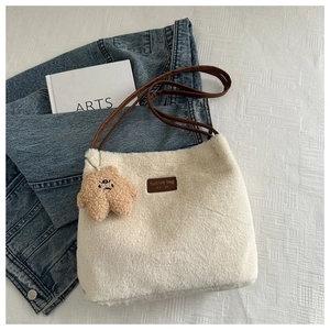 Détail du sac cabas en peluche blanche avec bandoulière en cuir brun et breloque étoile