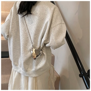 Détail du mini sac cœur géométrique en métal argenté avec surface polie taillée en diamant