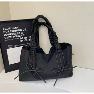 Détail du sac cabas plissé noir avec coutures blanches contrastées et nœuds décoratifs