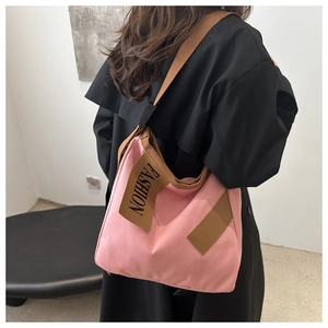 Détail du sac fourre-tout rose en toile avec patch fashion et bandoulière marron contrastée