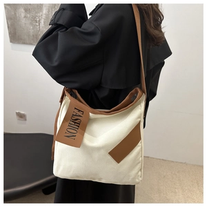 Vue détaillée du grand sac en toile avec bordure marron et écusson en cuir FASHION