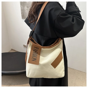 Détail du grand sac cabas en toile avec bordure marron et écusson FASHION