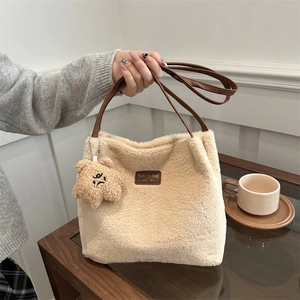 Sac cabas minimaliste en peluche beige avec anses en cuir marron et pendentif ours