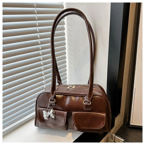 Detail der dunkelbraunen Retro-Schultertasche mit doppelten Fronttaschen und Silber-Schleife