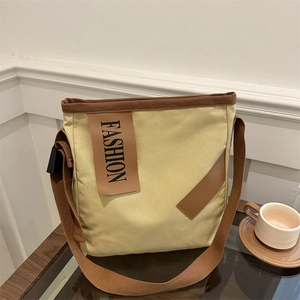 Sac cabas minimaliste en toile beige avec sangles brunes et patch mode pour le quotidien