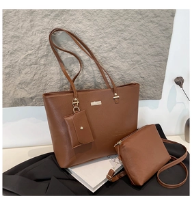 Detail of dark brown lychee grain PU leather tote bag set with metal hardware trim