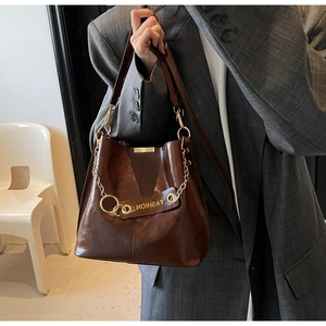 Detail view of dark brown retro bucket bag with polished oil-wax leather and chain strap