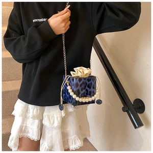 Detail der Mini-Box-Tasche mit Leopardenmuster, Perlengriff und goldener Kettenriemen