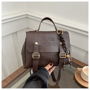 Detail of dark brown retro leather backpack with metal buckles and brand logo