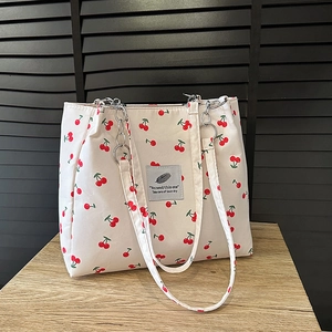White canvas tote bag with red cherry print and silver chain strap for women