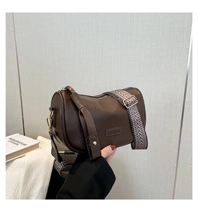 Detail of dark brown Boston bag featuring vintage leather texture and wide woven strap