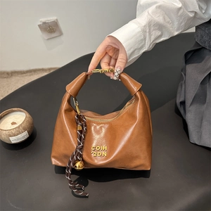 Vintage crescent hobo bag in brown leather with gold hardware and woven pendant