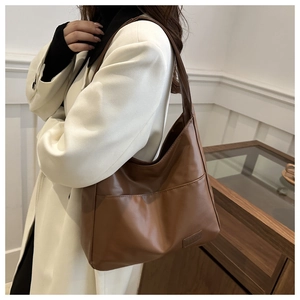 Dettaglio della borsa tote vintage marrone che mostra la trama in pelle e la tasca frontale