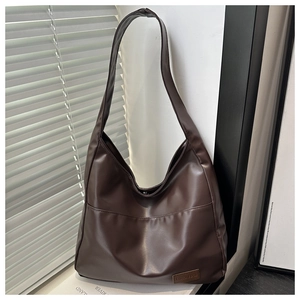 Dettaglio ravvicinato della borsa tote in pelle PU color caffè con etichetta moda