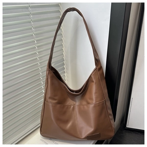 Dettaglio della borsa tote marrone scuro con pelle morbida ed etichetta alla moda
