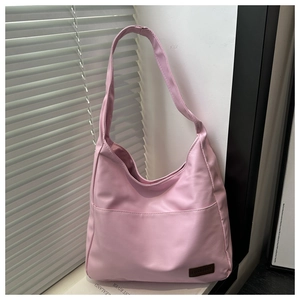 Dettaglio borsa tote rosa minimalista con etichetta in pelle e tessuto nylon impermeabile