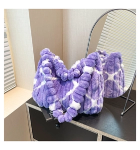 Detail of purple and white faux fur plaid tote bag with ruffled handles in a soft home setting