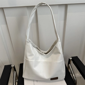 Borsa hobo minimalista in pelle PU bianca su sedia per ufficio e abbigliamento casual