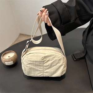 Chic cream nylon crossbody bag for women with adjustable strap shown in a lifestyle setting