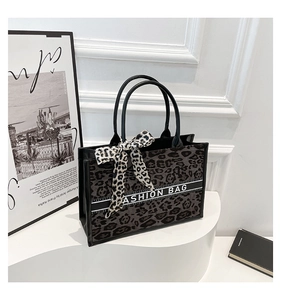 Détail du sac cabas léopard gris avec poignées noires et foulard décoratif tendance