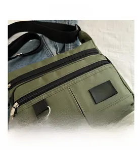 Detail der armee-grünen Nylon-Umhängetasche mit dichtem Stoff und Reißverschlussfächern