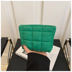 Close-up of vibrant green quilted cosmetic bag with minimalist square stitching detail