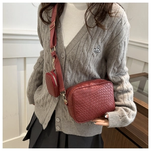 Dettaglio borsa a tracolla intrecciata rosso scuro in pelle con mini portamonete