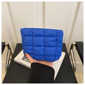 Detail of bright blue quilted pouch in high-quality nylon with square pattern