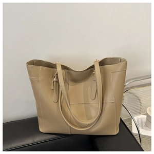 Detail of khaki tote bag showing contrast white stitching and adjustable metal buckle