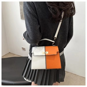 Vue détaillée du sac à main bicolore avec panneaux orange et blanc porté par un mannequin