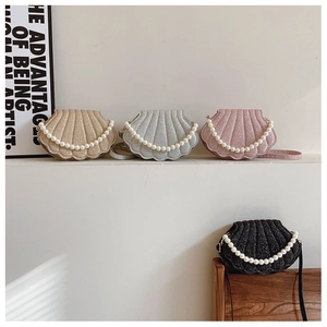 Macro shot of seashell-shaped sequin bags with elegant pearl handles and metallic textures