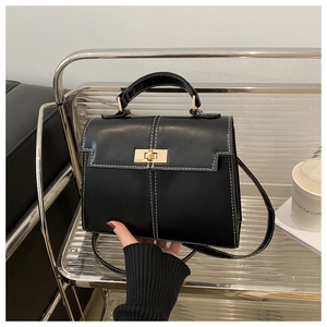 Detail of black leather Kelly bag with contrast stitching and gold buckle