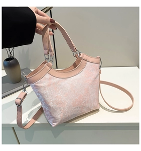 Detailed close-up of pink silk embroidery handbag with silver hardware and handle