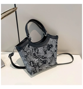 Detail of floral printed canvas bucket bag with leather handles and adjustable strap