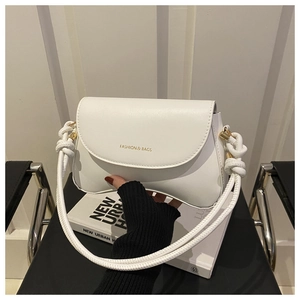 Detail of the white leather saddle bag showing wave flap and woven rope shoulder strap