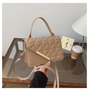Vue détaillée du sac matelassé crème avec boucle dorée et texture en cuir synthétique