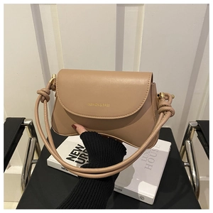 Detail of nude khaki faux leather bag with gold logo and knotted shoulder strap