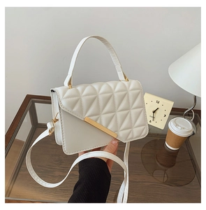 Détail du sac à bandoulière matelassé blanc avec garniture dorée et poignée supérieure