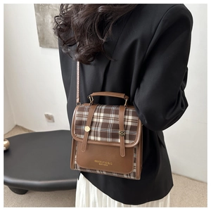 Detail of vintage plaid crossbody bag with leather stitching and adjustable strap