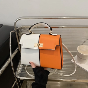 Elegant white and orange Kelly style handbag with gold lock and adjustable shoulder strap