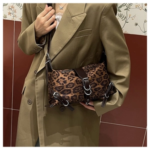 Dettaglio della borsa leopardata con finiture in pelle marrone e fibbie metalliche