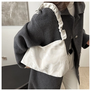 Detail of marble pattern shoulder bag featuring a unique pleated cloud-style strap