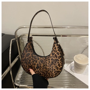 Detail of leopard print crescent bag showing the smooth zipper and slim leather strap