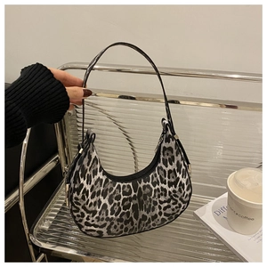 Detail of hobo crescent bag featuring black and white leopard print with metal rivet