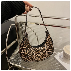 Detail shot of stylish leopard print crescent bag featuring a sleek metal zipper closure
