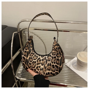 Detail view of the leopard print crescent bag with sleek black trim and metal zipper