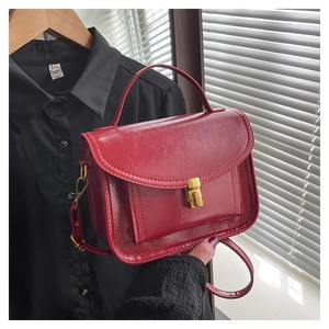 Détails du sac messager rétro en cuir rouge avec fermoir doré et texture raffinée