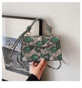 Detailed view of the snakeskin textured mini crossbody bag with a knotted handle detail